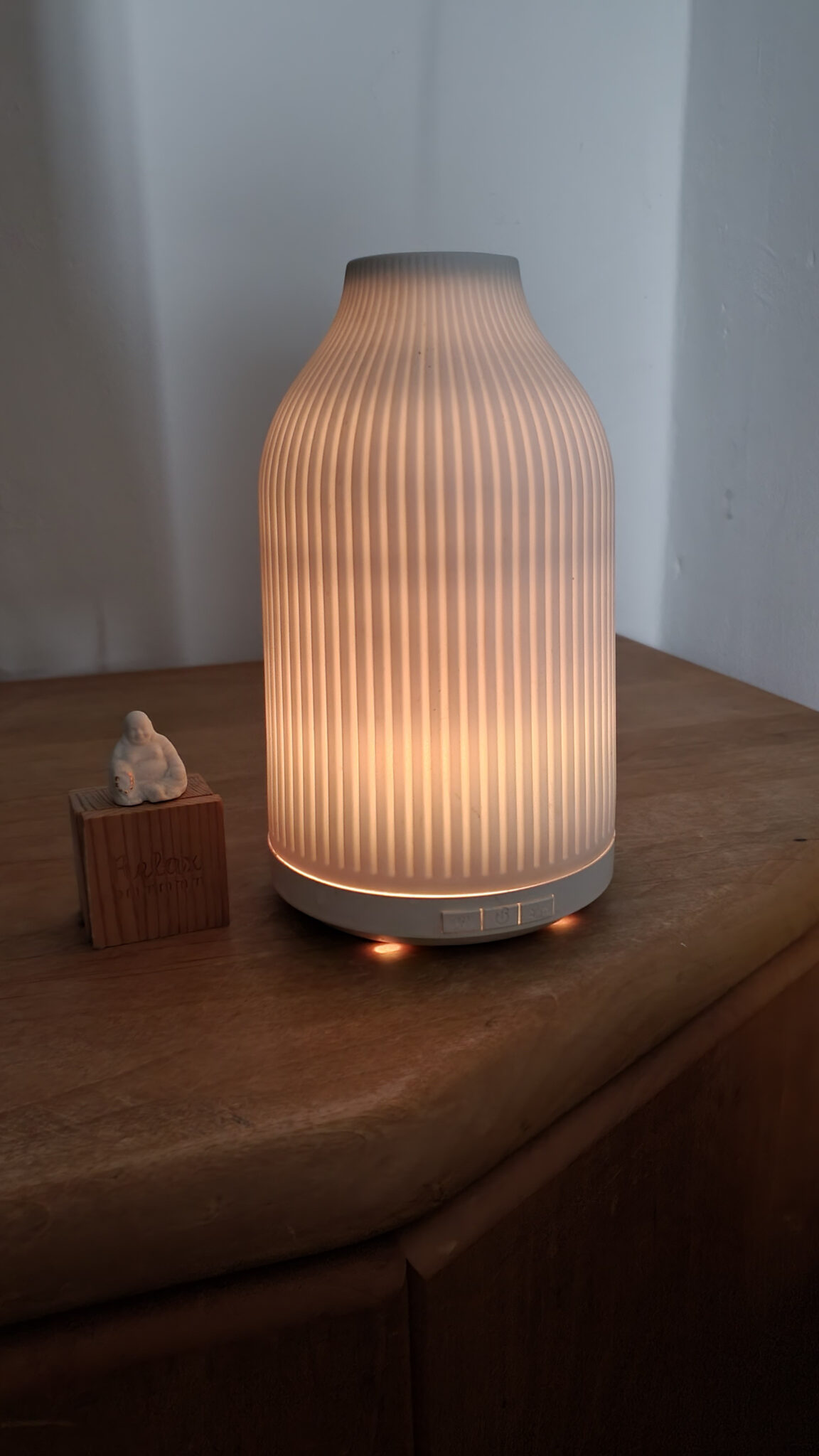 Ein Diffuser mit warmem Licht auf einer Kommode